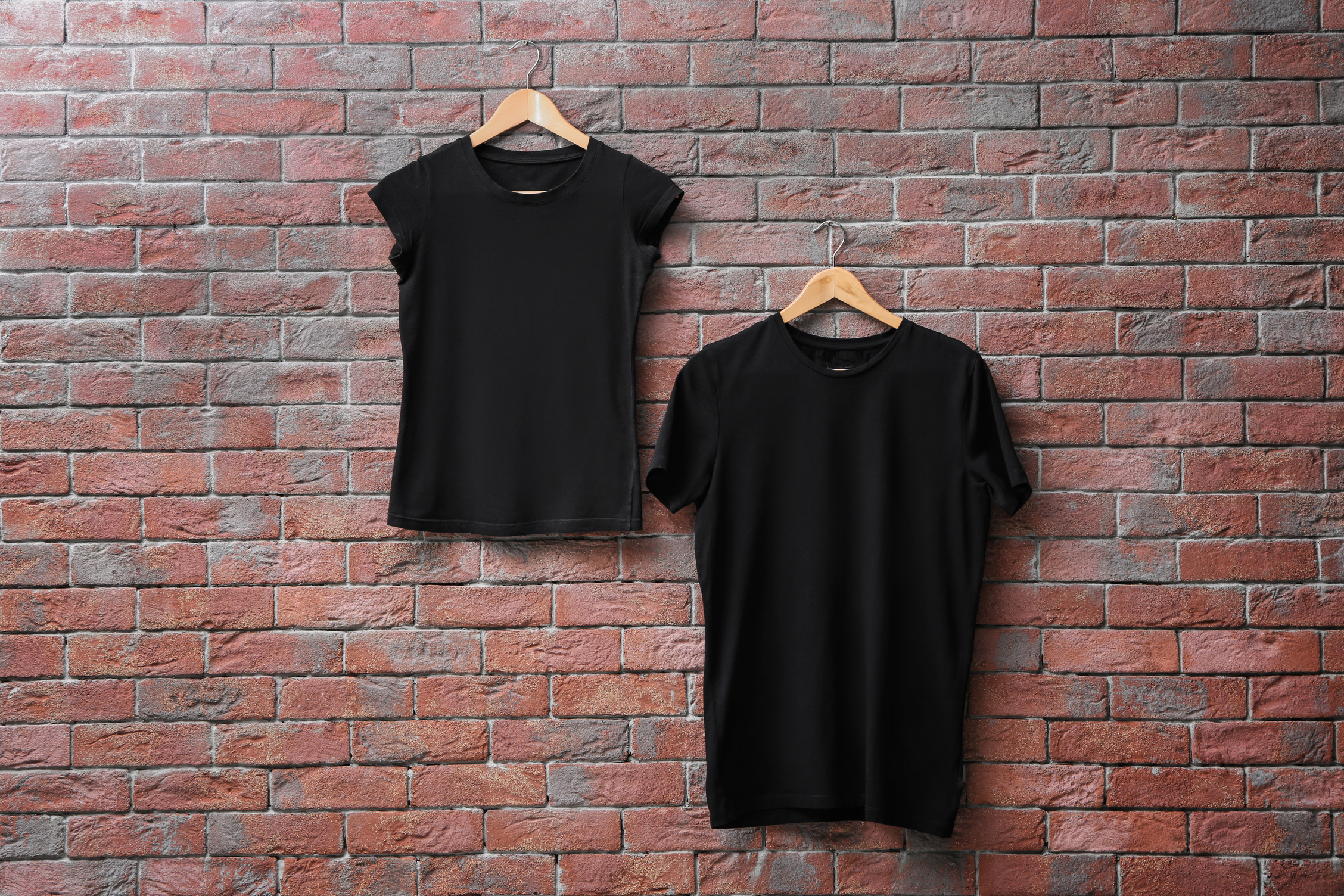Black T-shirts on Hanger Against Brick Wall